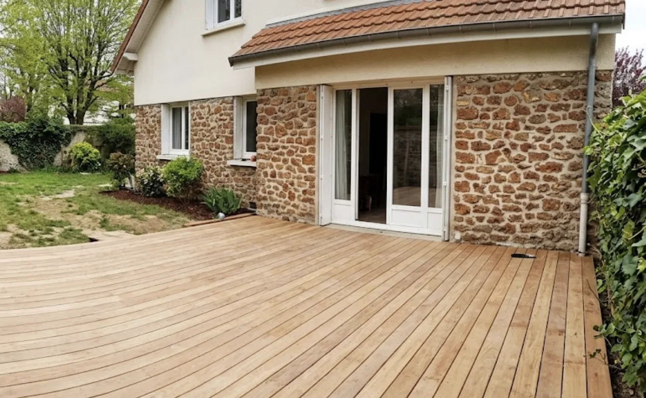 Terrasse en bois posée contre une maison en meulière à Chatou